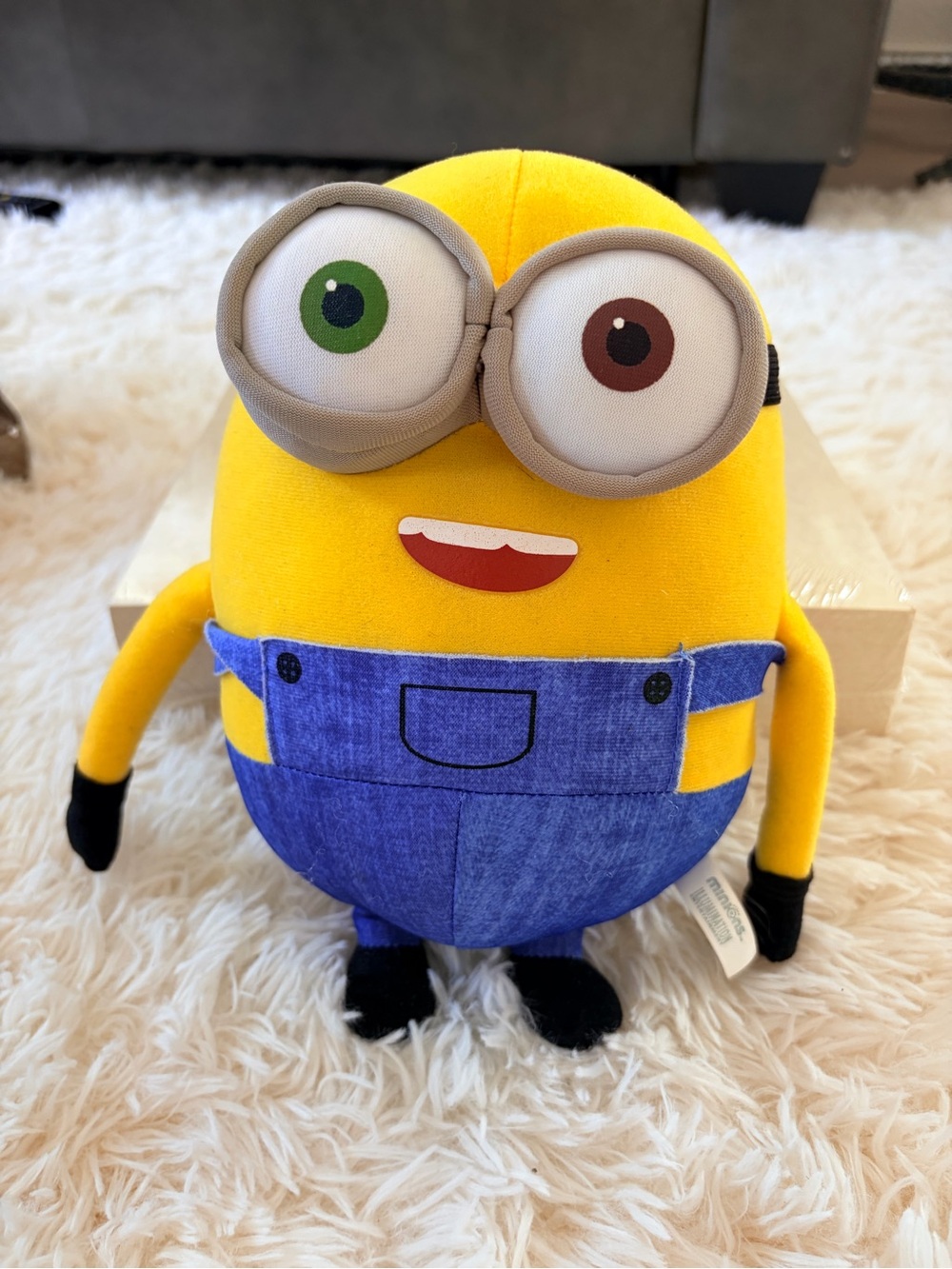 Yellow Plush Character with Blue Overalls and Mismatched Eyes
